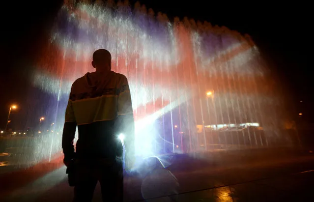 A man stands in front of a fountain illuminated with the colours of the United Kingdom flag on May 23, 2017, in Zagreb, during a tribute to victims of an attacks claimed by Islamic State which killed at least 22 people and left more than 60 injured in Manchester the day before. Twenty two people have been killed and dozens injured in Britain' s deadliest terror attack in over a decade after a suspected suicide bomber targeted fans leaving a concert of US singer Ariana Grande in Manchester. British police on May 23 named the suspected attacker behind the Manchester concert bombing as Salman Abedi, but declined to give any further details. (Photo by AFP Photo/Stringer)