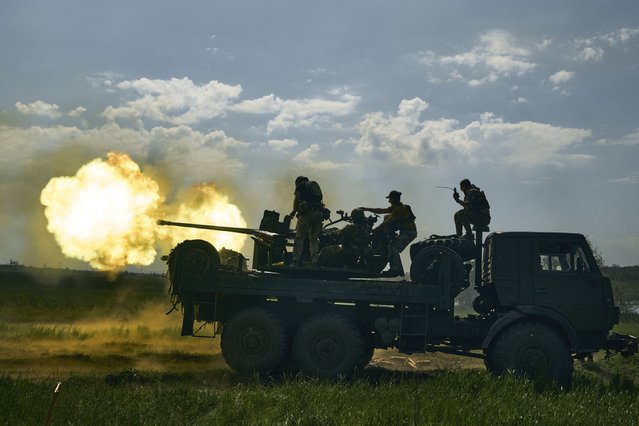 Ukrainian soldiers fire a cannon near Bakhmut, an eastern city where fierce battles against Russian forces have been taking place, in the Donetsk region, Ukraine, Monday, May 15, 2023. (Photo by Libkos/AP Photo)