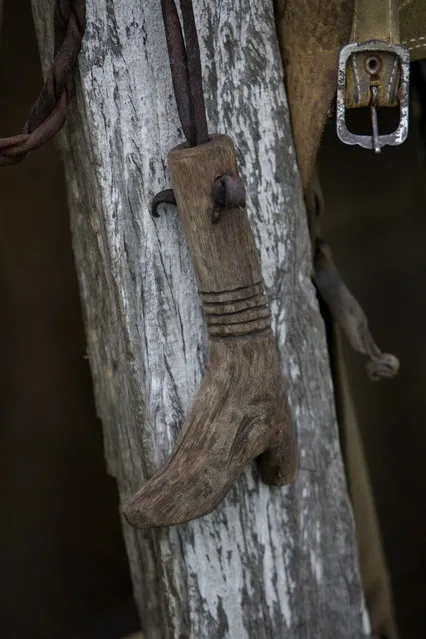 In this May 16, 2017 photo, a handmade whip handle, in the shape of a boot, hangs in a cowboy camp in Corumba, in the Pantanal wetlands of Mato Grosso do Sul state, Brazil. The whip was made by one of the ranch hands who helps round up cattle. (Photo by Eraldo Peres/AP Photo)