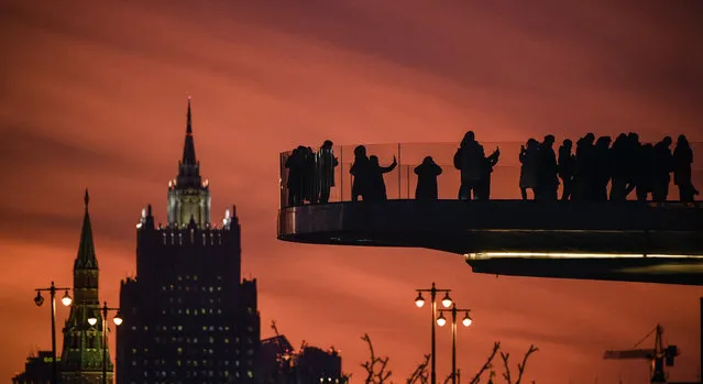 People enjoy the views from a pedestrian bridge at the Zaryadye Park during sunset in downtown Moscow on November 25, 2019. (Photo by Alexander Nemenov/AFP Photo)