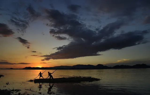 Sun and a cloudy sky as Indian vendors steer a bamboo rack at the bank of the Brahmaputra river in Guwahati city, India, July 25, 2015. The 2,900 km long Brahmaputra River is trans-boundary river and one of Asia's longest rivers. It passes through Tibet into India and Bangladesh before flowing into the Bay of Bengal. (Photo by EPA/Stringer)