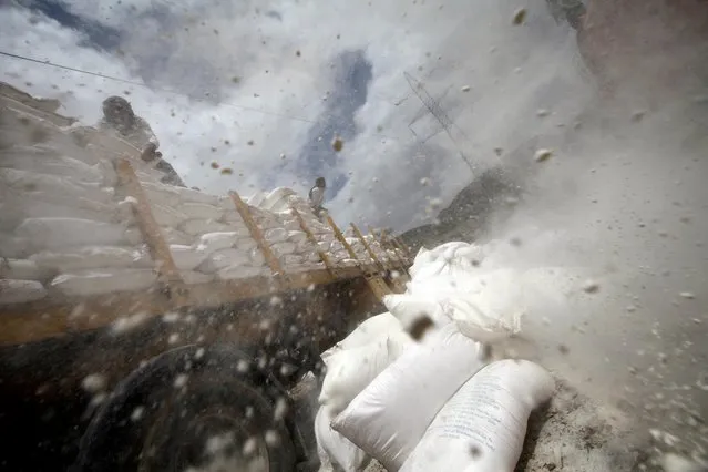 Workers dispose of sacks of wheat flour which reportedly expired after they were provided by the World Food Program (WFP), on the outskirts of Sanaa, Yemen August 28, 2019. (Photo by Mohamed al-Sayaghi/Reuters)
