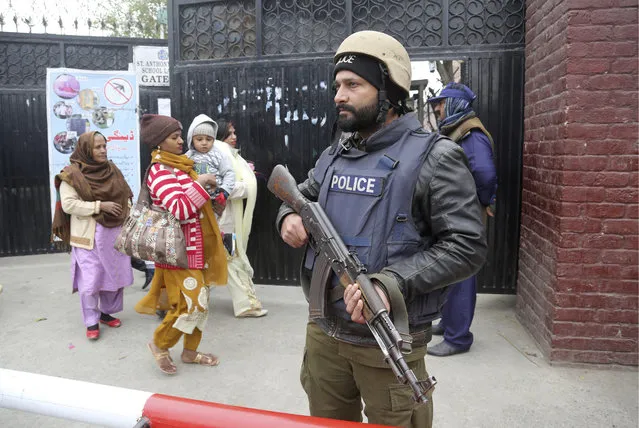 A police commando stands guard outside a church during Christmas Mass in Lahore, Pakistan, Wednesday, December 25, 2019. (Photo by K.M. Chaudary/AP Photo)