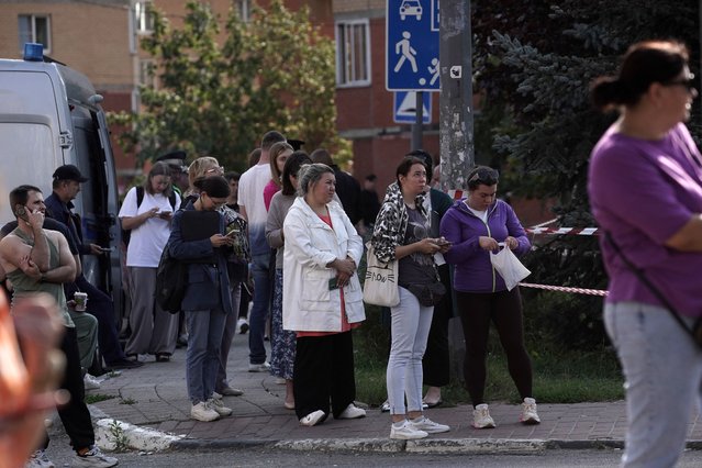 People gather outside of a damaged residential building following a drone attack in Ramenskoye in the Moscow region on September 10, 2024. A massive wave of Ukrainian drones set off air defences across several Russian regions, officials said on September 10, 2024, killing at least one person and grounding flights in the capital. (Photo by Tatyana Makeyeva/AFP Photo)