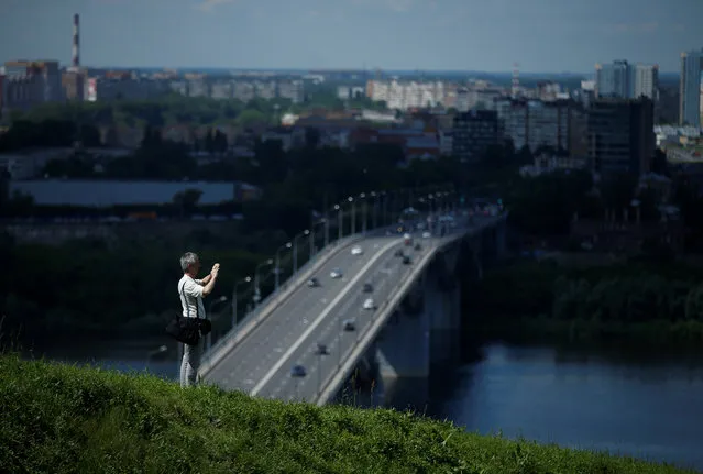 A man takes pictures from the hill near the confluence of Oka and Volga rivers in Nizhny Novgorod, Russia on July 12, 2017. (Photo by David Mdzinarishvili/Reuters)
