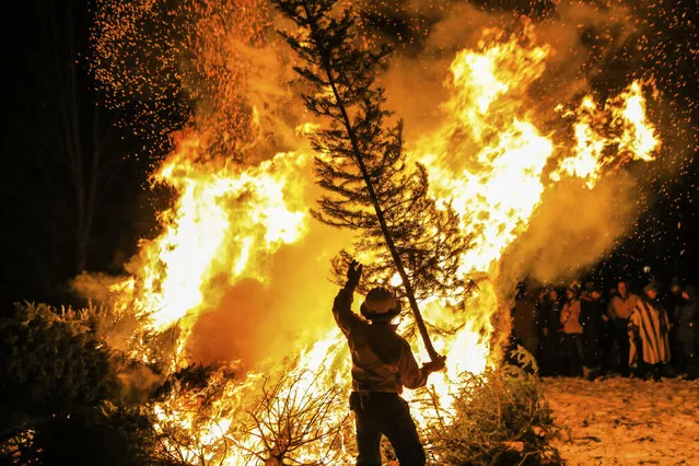 Greater Eagle Fire Protection District Wildland Fire Specialist Ross Wilmore tosses another tree on the bonfire during the annual 12th Night tradition, Monday, January 6, 2020, in Eagle, Colo. The annual bonfire rids the town of unwanted Christmas trees. (Photo by Chris Dillmann/Vail Daily via AP Photo)