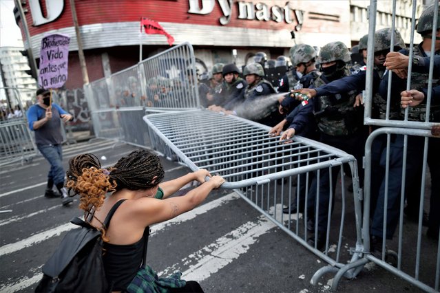 A woman tries to remove a police barricade during a protest against copper mining in front of the National Assembly in Panama City, Panama 28 August 2023. More than a hundred people protested against a new contract of Minera Panama, a subsidiary of Canadian First Quantum Minerals, that operates the largest open-pit copper mine in Central America, under a tense atmosphere and clashes with police that left some minor injuries. (Photo by Bienvenido Velasco/EPA/EFE)