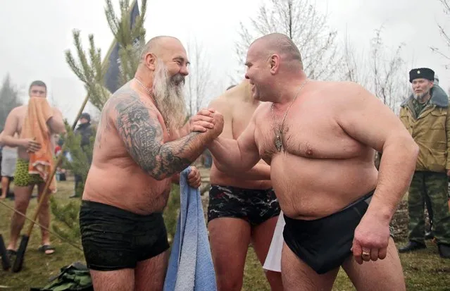 Men after taking a dip in a pond on the feast day of Epiphany, near St George's Church in Alchevsk, Lugansk Region, Ukraine on January 19, 2020. Orthodox Christians celebrate Epiphany according to the Julian calendar. (Photo by Alexander Reka/TASS)