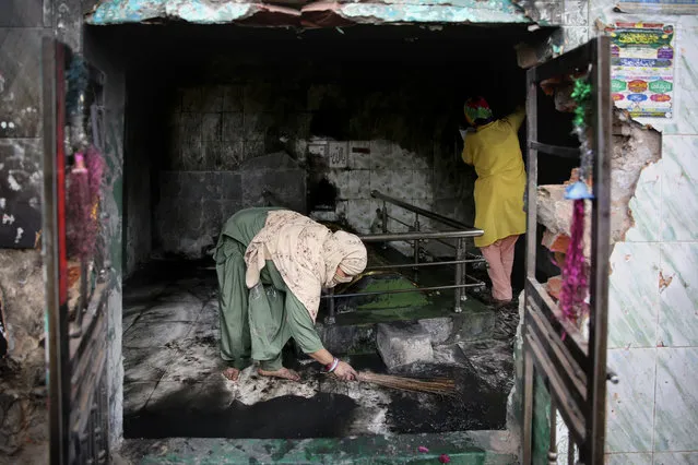 A Muslim woman cleans a shrine burnt in Tuesday's violence in New Delhi, India, Thursday, February 27, 2020. (Photo by Altaf Qadri/AP Photo)