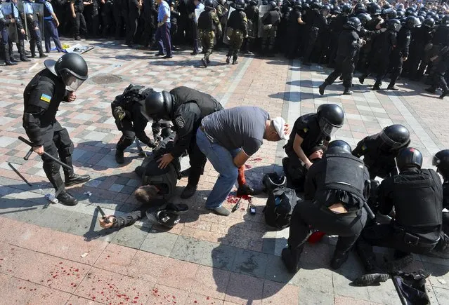 Ukrainian police officers assist injured colleagues outside the parliament building in Kiev, Ukraine, August 31, 2015. (Photo by Reuters/Stringer)