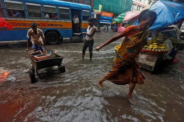 A woman pulls a handcart through a waterlogged road as it rains in Kolkata, India, July 25, 2016. (Photo by Rupak De Chowdhuri/Reuters)