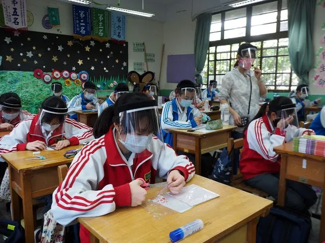 Tsai Li-mei (R) teaches a plastic arts class at the Nankan Junior High School in Taoyuan City, Taiwan, on April 28, 2020. Tsai helped students make face shields for themselves to prevent being infected by the COVID-19 disease. (Photo by Siphiwe Sibeko/Reuters)