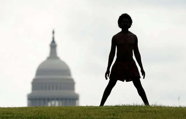 With the dome of the U.S. Capitol in the background,  a homeless man named Damu stretches on the National Mall  in Washington, U.S., May 27, 2020. (Photo by Kevin Lamarque/Reuters)