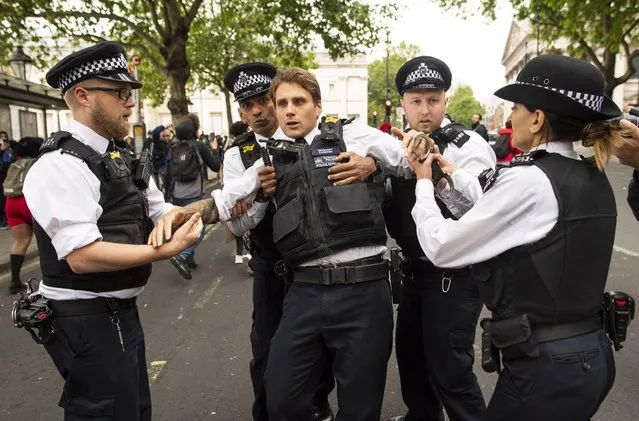 An injured police officer, who appeared to have been struck in the head by a thrown object, is assisted by his colleagues during a Black Lives Matter protest at Trafalgar Square on June 03, 2020 in London, England. The death of an African-American man, George Floyd, while in the custody of Minneapolis police has sparked protests across the United States, as well as demonstrations of solidarity in many countries around the world. (Photo by Justin Setterfield/Getty Images)