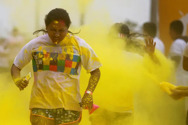 Participants are covered in colored powder as they compete in The Color Run in Lima, Peru, August 14, 2016. (Photo by Guadalupe Pardo/Reuters)