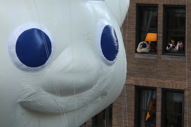 People take photos of the Pillsbury Dough Boy balloon as it takes part in the 91st Macy's Thanksgiving Day Parade in New York, New York on November 23, 2017. (Photo by Carlo Allegri/Reuters)