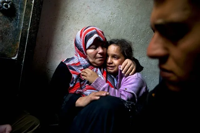 Samiha Abu Wardah comforts her daughter, Nancy, 9, after Wardah's son was reportedly killed in a rocket attack in Gaza City. (Photo by Tyler Hicks/The New York Times)