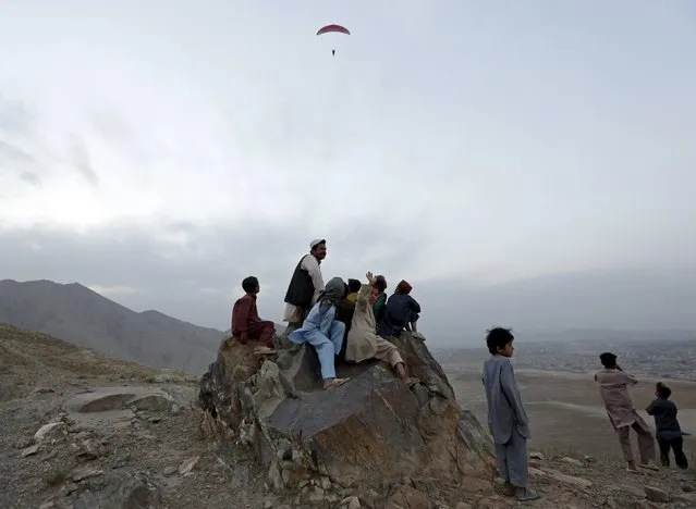 Afghans watch a paraglider in flight in Kabul, Afghanistan September 19, 2015. (Photo by Mohammad Ismail/Reuters)