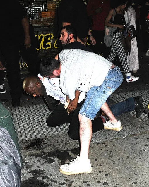 A man with broken bottle glass slashes two other men on 14th Street in Manhattan, New York on August 27, 2016. The man who is unnamed was later arrested by police following the fight as he ran down a street with the broken bottle. Pictured: Man with broken bottle glass slashes two other men. (Photo by Demis Maryannakis/Splash News and Pictures)