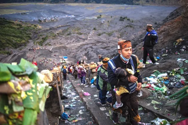 Tengger tribe people make their way to the summit of Mount Bromo volcano to make offerings in Probolinggo, East Java province on July 7, 2020, as part of the Yadnya Kasada Festival. During the annual Yadnya Kasada festival, the Tenggerese climb Mount Bromo, an active volcano, and seek the blessing from the main deity by presenting offerings of rice, fruit, livestock and other items. (Photo by Juni Kriswanto/AFP Photo)