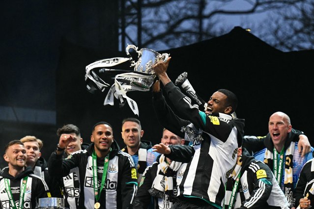 Newcastle United's Swedish striker #14 Alexander Isak celebrates with the League Cup trophy on stage at the Town Moor in Newcastle upon Tyne, in north-east England, on March 29, 2025, during a celebration and presentation with fans after Newcastle United won the English League Cup, their first domestic trophy for 70 years. (Photo by Oli Scarff/AFP Photo)