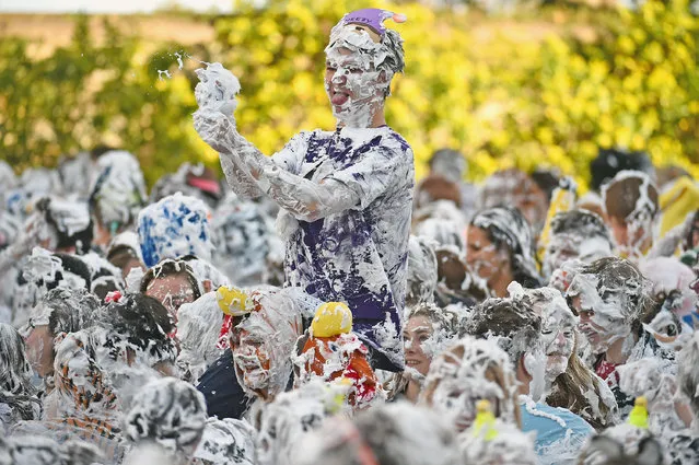 Students from St Andrew's University indulge in a tradition of covering themselves with foam to honour the “academic family” on October 20, 2014, in St Andrews, Scotland. Every November the “raisin weekend” which is held in the university's Lower College Lawn, is celebrated and a gift of raisins (now foam) is traditionally given by first year students to their elders as a thank you for their guidance and in exchange they receive a receipt in Latin. (Photo by Jeff J. Mitchell/Getty Images)