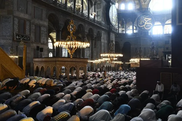 People pray inside the Byzantine-era Hagia Sophia, during afternoon prayers, in the historic Sultanahmet district of Istanbul, Friday, July 24, 2020. Worshipers earlier held the first Muslim prayers in 86 years inside the Istanbul landmark that served as one of Christendom's most significant cathedrals, a mosque and a museum before its conversion back into a Muslim place of worship. The conversion of the edifice, has led to an international outcry. (Photo by Omer Kuscu/AP Photo)