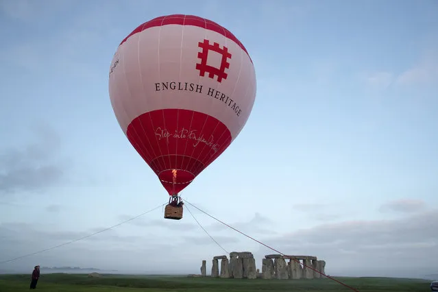 A tethered hot air balloon flies over the ancient neolithic monument of Stonehenge near Amesbury on September 7, 2016 in Wiltshire, England. (Photo by Matt Cardy/Getty Images)