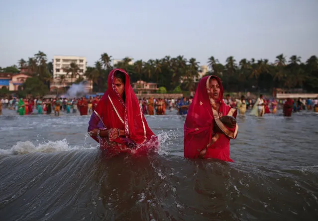 Hindu devotees pray while standing in the waters of the Arabian Sea as they worship the Sun god Surya during the Hindu religious festival Chatt Puja in Mumbai October 29, 2014. (Photo by Danish Siddiqui/Reuters)