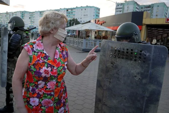 A woman gestures as she talks with riot police officers in the capital of Minsk, Belarus, Tuesday, August 11, 2020. Heavy police cordons blocking Minsk's central squares and avenues didn't discourage demonstrators who again took to the streets chanting “Shame!” and “Long live Belarus!” as police moved quickly Tuesday to separate and disperse scattered groups of protesters in the capital, but new pockets of resistance kept mushrooming across downtown Minsk. (Photo by Sergei Grits/AP Photo)
