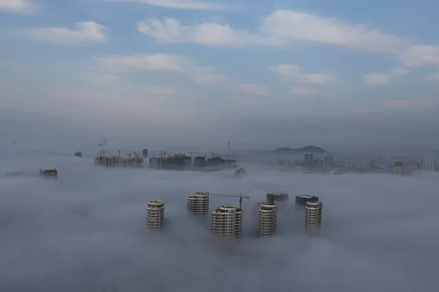 Buildings and construction sites are seen among fog in Rizhao, Shandong province, China, June 2, 2017. (Photo by Reuters/China Stringer Network)