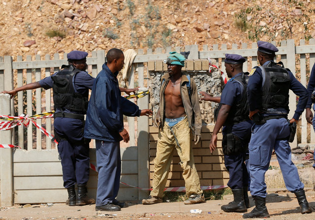 An alleged illegal miner is questioned by police after he emerged from an underground Johannesburg's oldest gold mine in Langlaagte, South Africa, September 12,2016. Picture taken Semptember 12, 2016. (Photo by Siphiwe Sibeko/Reuters)