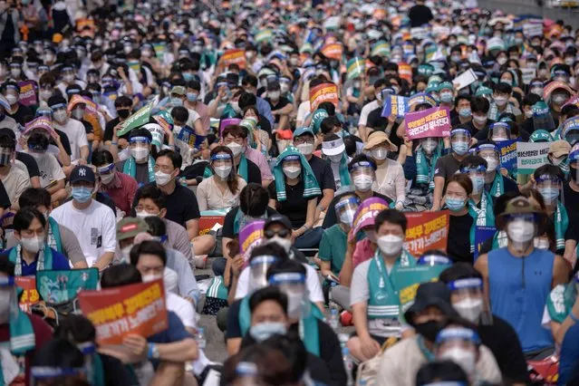 Doctors, medical students and healthcare professionals wearing face masks and protective equipment as part of preventative measures against the COVID-19 coronavirus attend a rally to protest against a government proposal to increase its annual intake of medical students, in the Yeouido district of Seoul on August 14, 2020. Thousands of South Korean doctors and medical staff were on strike protesting against the government proposal to increase the annual intake of medical students in order to increase the number of doctors and medical specialists especially in regions outside the capital and metropolitan areas. (Photo by Ed Jones/AFP Photo)