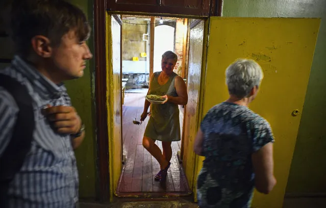 A woman stands at the entrance of a communal kitchen in a dormitory for the workers of Proletarka textile factory in the town of Tver, 200 kilometres north-west from Moscow on August 8, 2020. (Photo by Andrey Borodulin/AFP Photo)