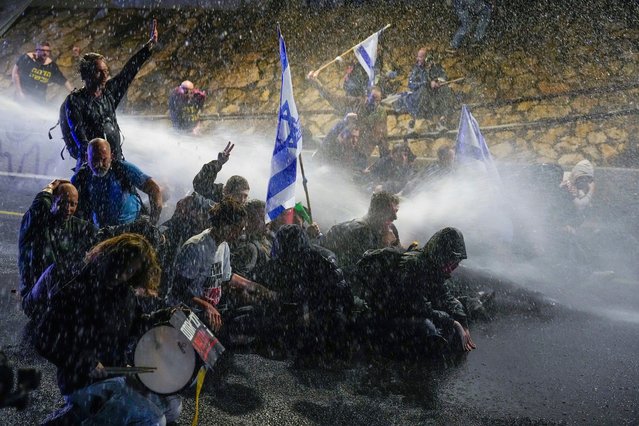 Police use water cannon to disperse demonstrators during a protest against Israeli Prime Minister Benjamin Netanyahu's government, and calling for the release of hostages held in the Gaza Strip by the Hamas militant group, in Tel Aviv, Israel, Saturday, March 9, 2024. (Photo by Ariel Schalit/AP Photo)