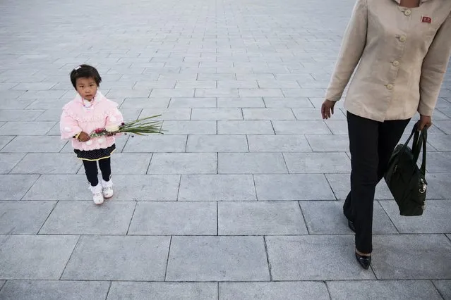 A woman and her daughter arrive to pay their respects at statues of North Korea founder Kim Il Sung and late leader Kim Jong Il in Pyongyang October 11, 2015. (Photo by Damir Sagolj/Reuters)
