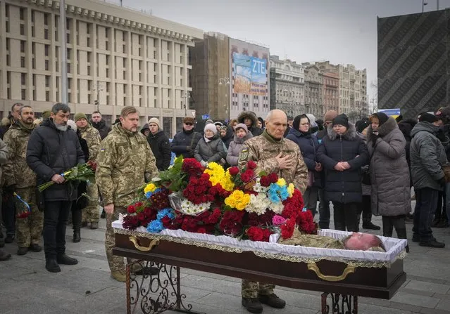 Ukrainian servicemen pay their last respect at the coffin of their comrade Oleh Yurchenko killed in a battlefield with Russian forces in the Donetsk region during a commemoration ceremony in Independence Square in Kyiv, Ukraine, Sunday, January 8, 2023. (Photo by Efrem Lukatsky/AP Photo)