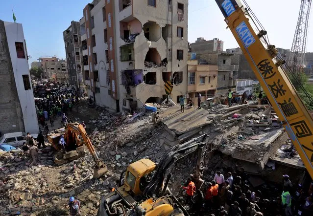 Pakistan troops, rescue workers and volunteers look for survivors amid the rubble of a collapsed building in Karachi, Pakistan, Thursday, September 10, 2020. The multi-story residential building collapsed in a neighborhood of Karachi, killing and injuring some people, local media reported. (Photo by Fareed Khan/AP Photo)