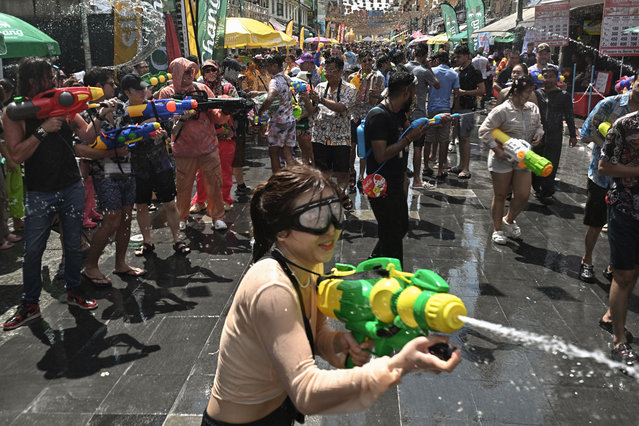 Revellers take part in mass water fights on the first day of Songkran, or Thai New Year, on Khao San Road in Bangkok on April 13, 2025. (Photo by Lillian Suwanrumpha/AFP Photo)
