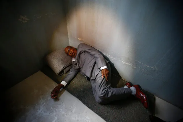 Andrew Mlangeni, South African political activist and former political prisoner demonstrates how he used to sleep on the floor in a prison cell during the launch of the replica of Nelson Mandela's Robben Island Prison Cell in Cape Town, South Africa, 26 September 2016. Former South African president and Nobel Peace laureate Nelson Mandela was imprisoned in a cell of these exact proportions for 27 years. This mobile replica will make its way around the country to enable young people who have never been to the Robben Island Museum to get a personal perspective of the history that unfolded on Robben Island and South Africa. (Photo by Nic Bothma/EPA)