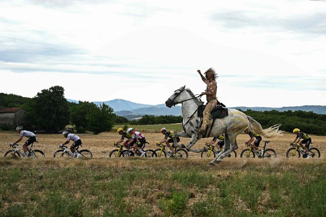 A man on horseback rides alongside the pack of riders (peloton) during the 17th stage of the 112th edition of the Tour de France cycling race, 160.4 km between Bollene and Valence, southern France, on July 23, 2025. (Photo by Loic Venance/AFP Photo)