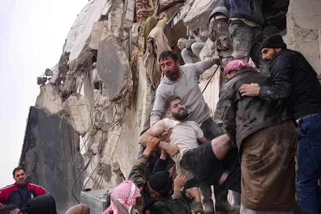 Residents retrieve an injured man from the rubble of a collapsed building following an earthquake in the town of Jandaris, in the countryside of Syria's northwestern city of Afrin in the rebel-held part of Aleppo province, on February 6, 2023. Hundreds have been reportedly killed in north Syria after a 7.8-magnitude earthquake that originated in Turkey and was felt across neighbouring countries. (Photo by Rami Al Sayed/AFP Photo)