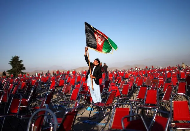 A supporter of Afghan presidential candidate Abdullah Abdullah holds an Afghan flag after an election campaign rally in the Paghman district of Kabul, in this June 9, 2014 file photo. (Photo by Ahmad Masood/Reuters)