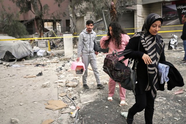 Residents leave the area where an apartment building was struck by an Israeli targeted attack in Dahiyeh, a southern suburb of Beirut, Lebanon, early Tuesday, April 1, 2025. (Photo by Hussein Malla/AP Photo)