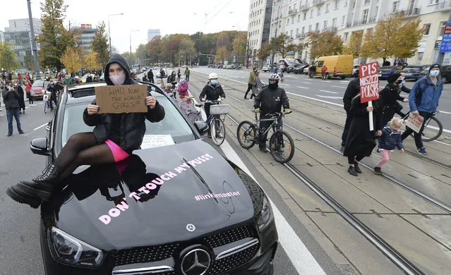 Women's rights activists hold placards during a protest in Warsaw, Poland, Wednesday, October 28, 2020 against recent tightening of Poland's restrictive abortion law. (Photo by Czarek Sokolowski/AP Photo)