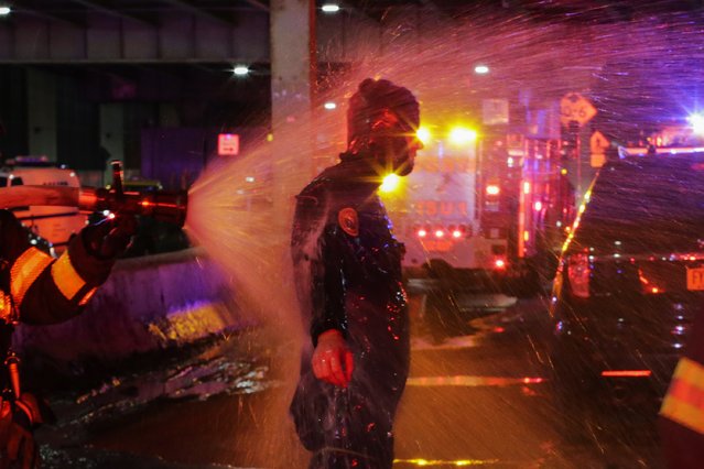 A FDNY diver is sprayed with water after attending a call of a helicopter crash in the East River on March 11, 2018 in New York City. According to reports at least two people were killed. (Photo by Eduardo Munoz Alvarez/Getty Images)