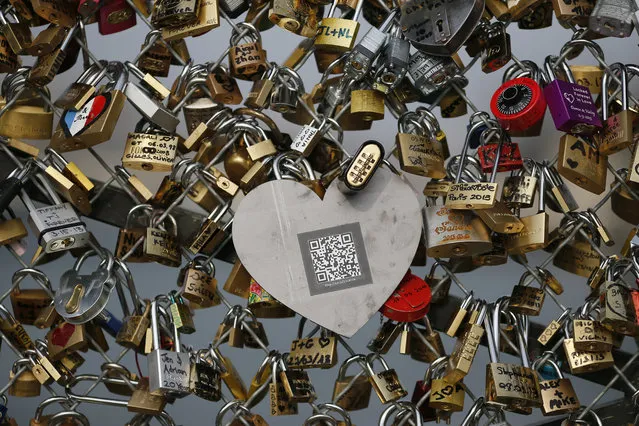 A picture taken on April 4, 2013 at the “Pont des Arts” in Paris shows one of the black heart-shaped padlocks symbolizing abused women which the French feminist movement “Ni Putes, Ni Soumises” (Neither Whores Nor Submissive – NPNS) founded in 2002 asked individuals to place on the bridge to mark its tenth anniversary. (Photo by Kenzo Tribouillard/AFP Photo)