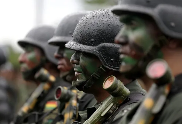 Officers of the Bolivian combined forces of army and police, who were tasked to eradicate coca leaves in the fight against drugs, attend the end of the ceremony for the task in Chimore, east of La Paz, December 10, 2014. (Photo by David Mercado/Reuters)