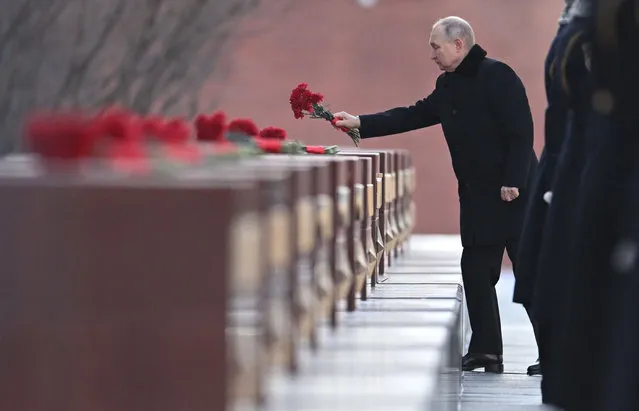Russian President Vladimir Putin lays flowers at the Moscow Kremlin Wall in the Alexander Garden during an event marking Defender of the Fatherland Day in Moscow on February 23, 2023. (Photo by Pavel Bednyakov/Sputnik via AFP Photo)
