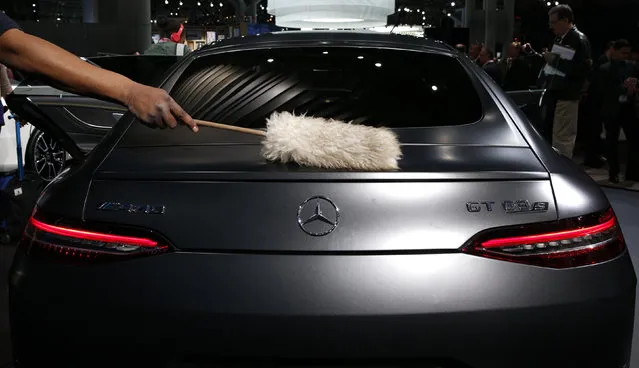 A worker is seen dusting a Mercedes-AMG GT 63S at the New York Auto Show in the Manhattan borough of New York City, New York, U.S., March 28, 2018. (Photo by Brendan McDermid/Reuters)